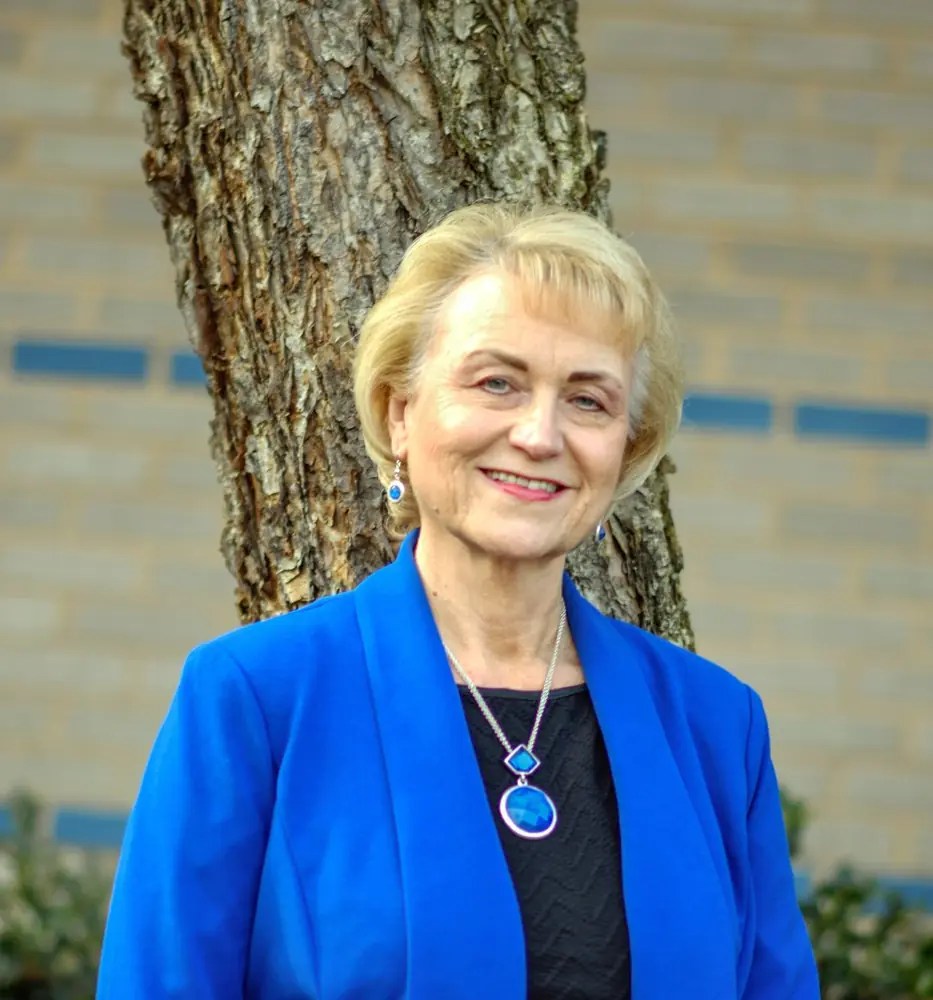 Debbie Kilpatrick in a blue jacket standing in front of a tree